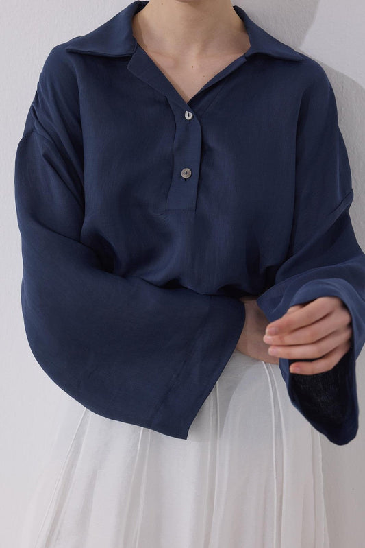 Cherianne.com navy blue linen blend blouse with a shirt collar, drop shoulders, and mother-of-pearl button detail.